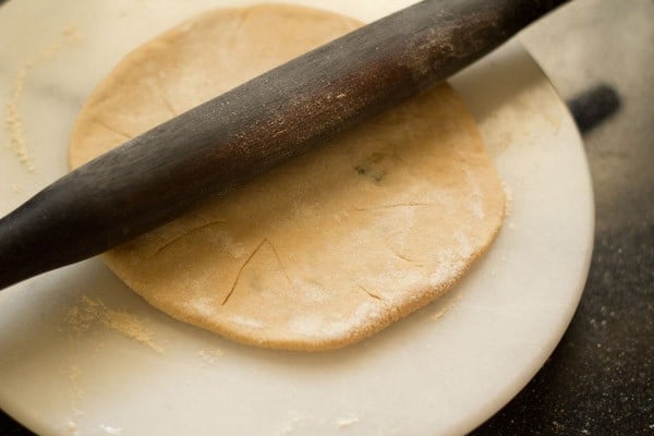 rolling aloo paratha with a rolling pin.