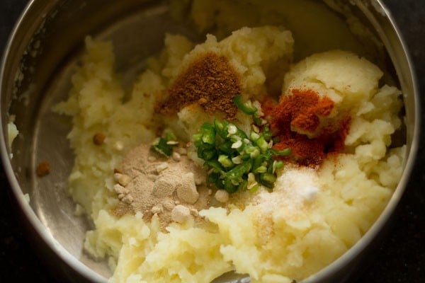 add spices and chilies to mashed aloo.