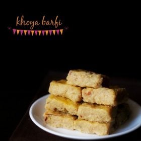 barfi squares stacked on top of one another and served on a white plate. with text layover.