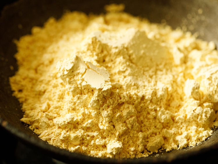 besan (gram flour) added in a heavy kadai or wok