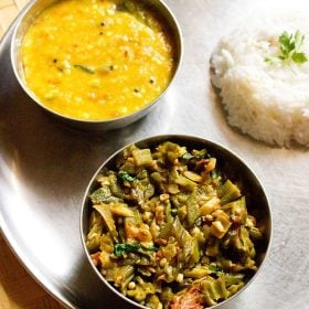 bhindi ki sabji served with dal and steamed rice in steel bowls.