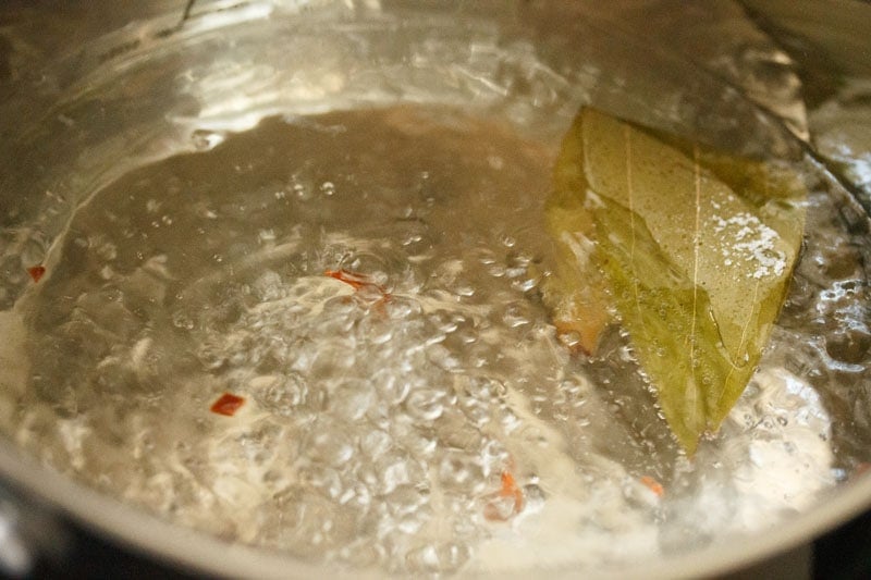 Top shot of water and spices boiling in pot for veg biryani recipe