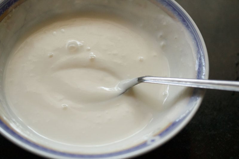 Top shot of white curd in a bowl with spoon