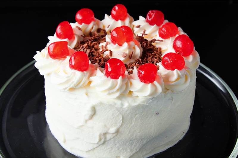 whole cherries and chocolate shavings added to the top of the black forest cake