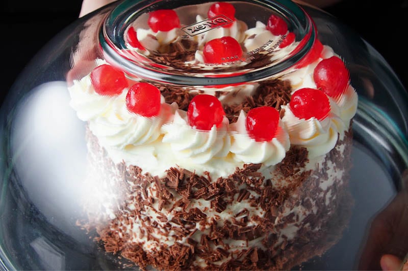glass bowl placed over the decorated black forest cake to protect it during refrigeration