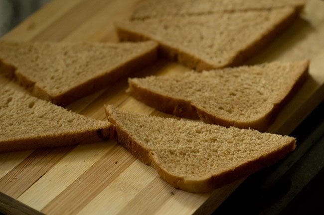 whole wheat bread sliced in triangles on a chopping board