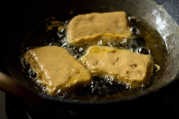 batter coated bread slices being fried in hot oil