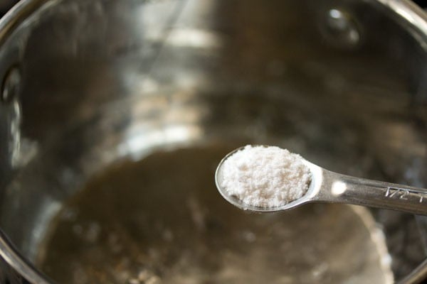 salt being added to the water in the pan