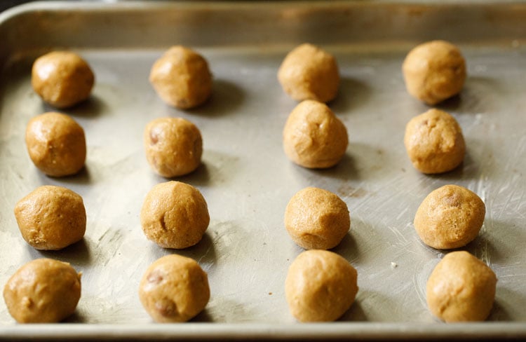 cookie dough balls placed on a greased baking tray
