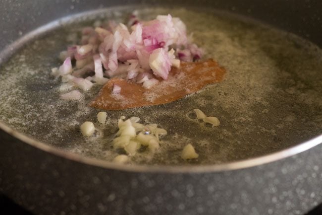 chopped onion, garlic, and bay leaf in pot