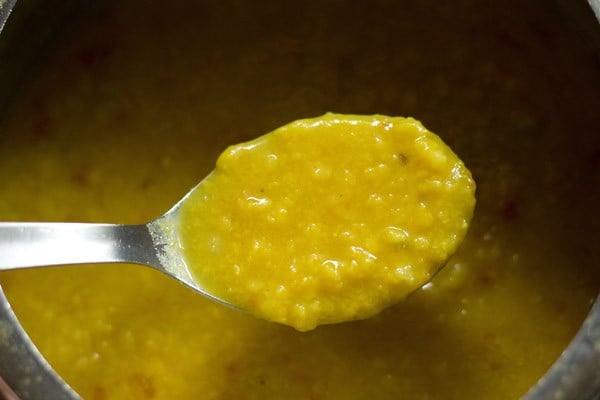 lentils have been cooked and the consistency of cooked lentils shown in a large spoon