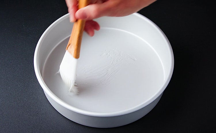 brushing cake pan with oil