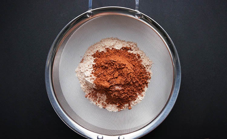 whole wheat flour and cocoa powder placed in a sieve for sifting