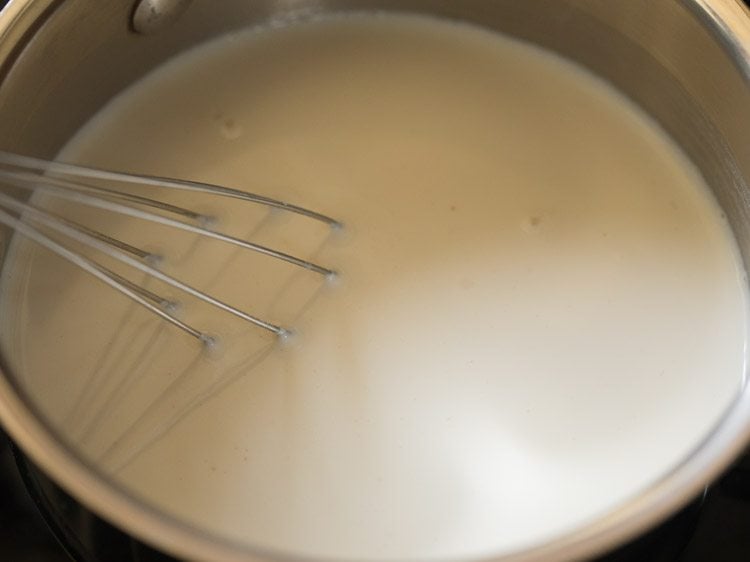 milk in pan with wired whisk inside.