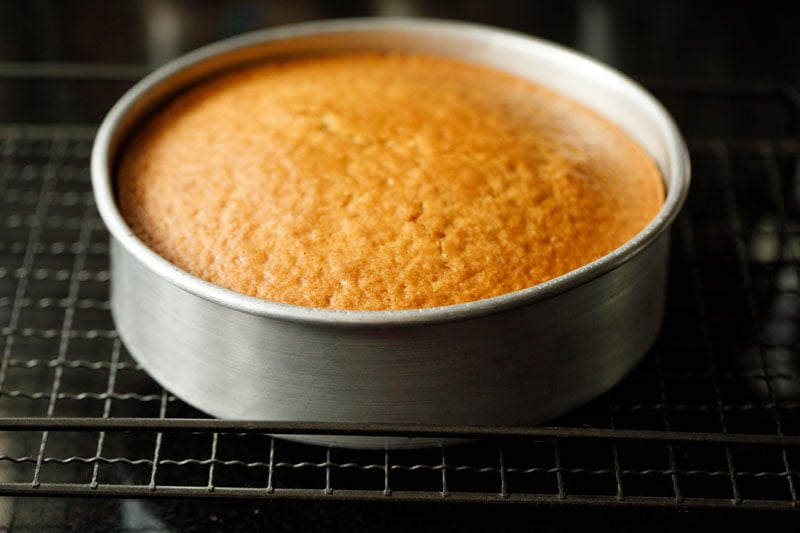 baked vanilla cake in the pan on a rack