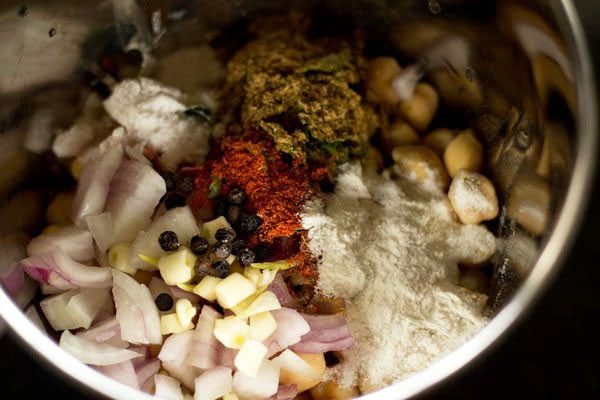 spices and herbs added to soaked chickpeas in the grinder jar