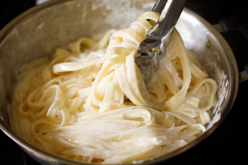 tossing fettuccine with Alfredo sauce
