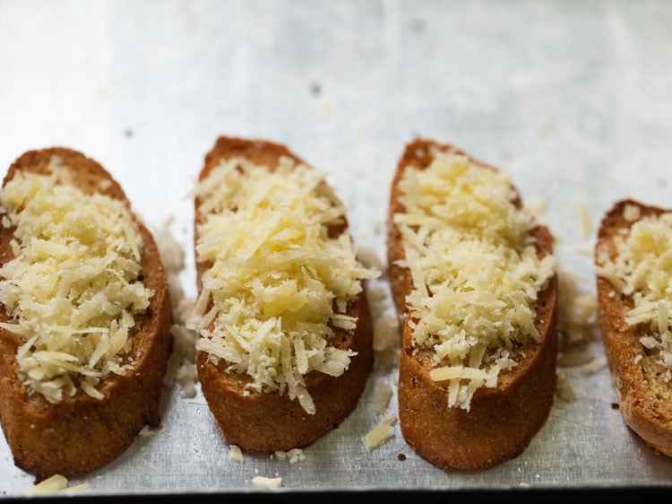 toasted baguette slices with grated gruyere cheese on them