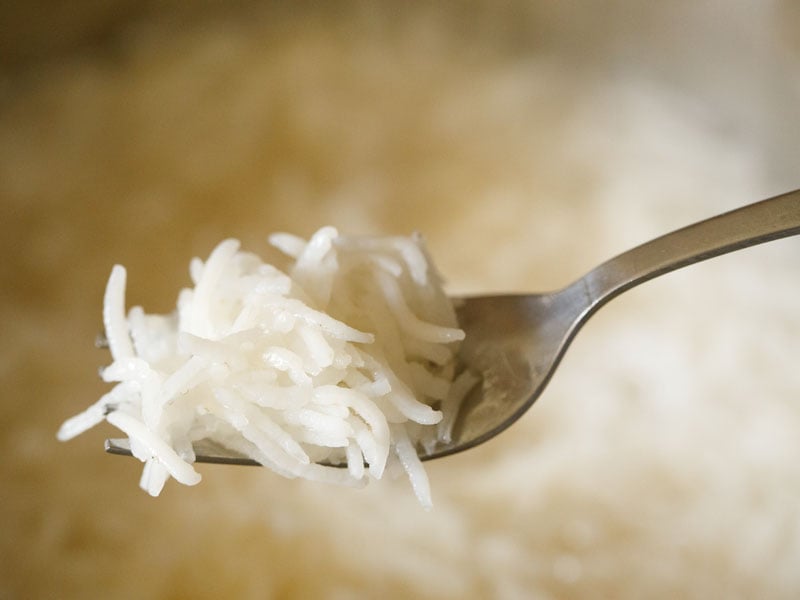 close up of cooked rice in a fork