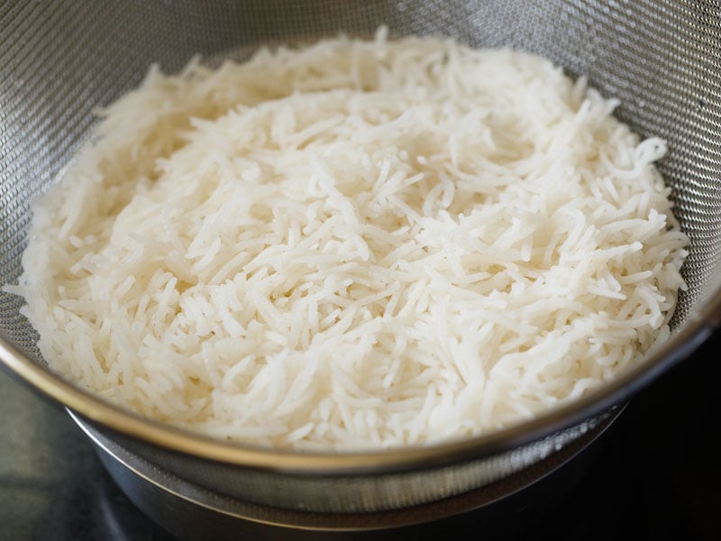 strain rice in colander for making veg fried rice