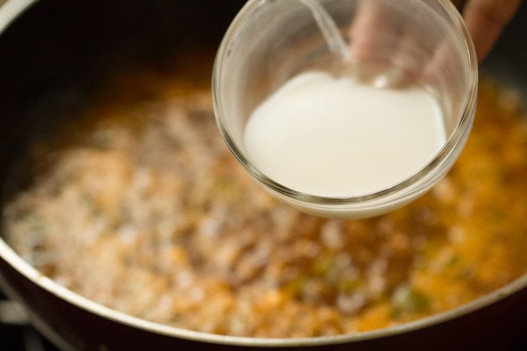 cornstarch paste being added to gravy or sauce in pan