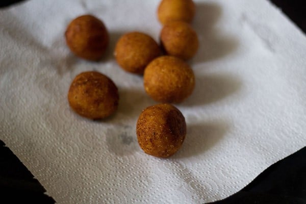 fried balls placed on paper towels to drain