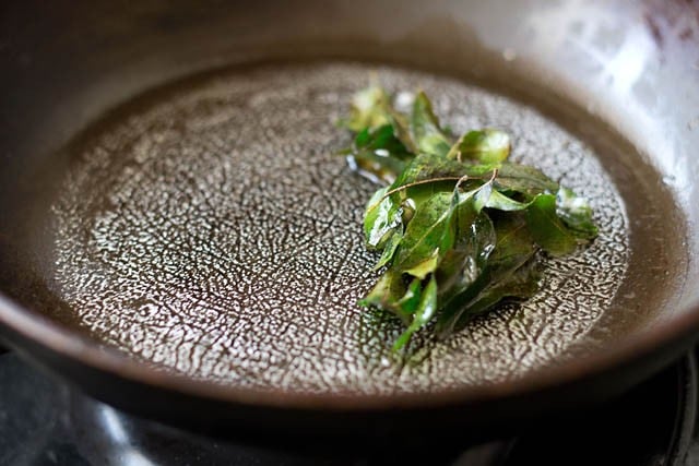 sautéing curry leaves in a pan