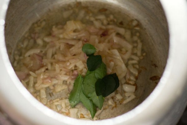 curry leaves added to sautéed onions in pressure cooker