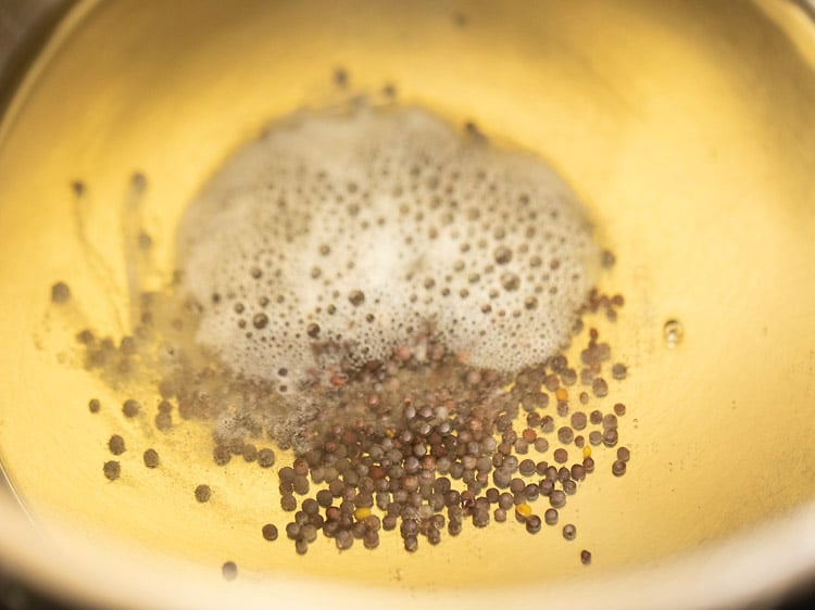 crackling mustard seeds in a pan