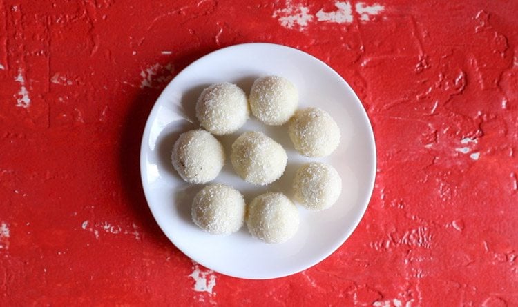 coconut ladoo placed on a white plate on red table