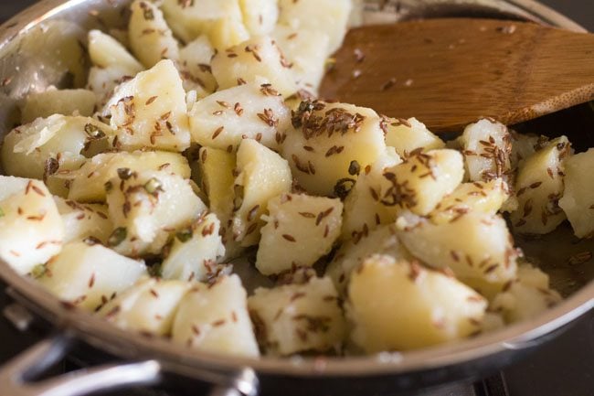 mixing potatoes with cumin and green chillies