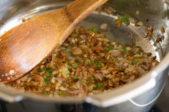 wooden spoon mixing chili-garlic-onion mix