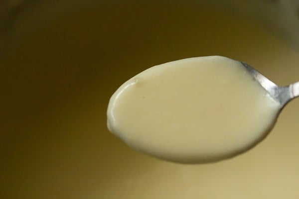 spoonful of creamy cheese sauce for mac and cheese recipe.