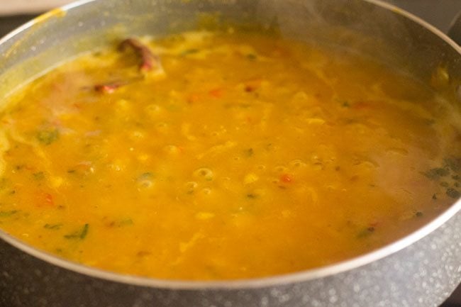simmering red lentils in pan.