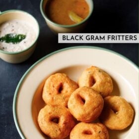 top shot of medu vada stacked neatly in green lined beige colored plate with cups filled with coconut chutney and sambar on the top with text layovers