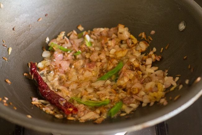 ginger, green chilies, dry red chili with sautéed onions in pan