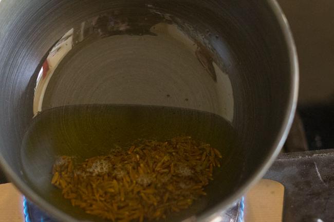cumin seeds frying in ghee in pan