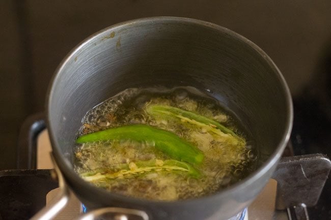 slit green chilies, garlic being fried in ghee. 