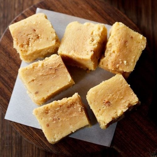 cubes of mysore pak on a wooden serving tray on a table.