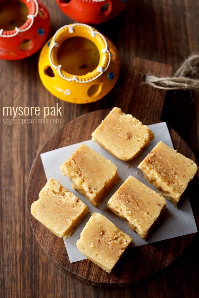 cubes of mysore pak on a wooden serving tray on a table.