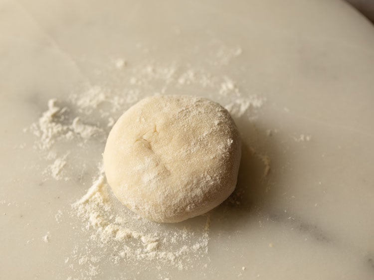 dough ball dusted with flour on a rolling board