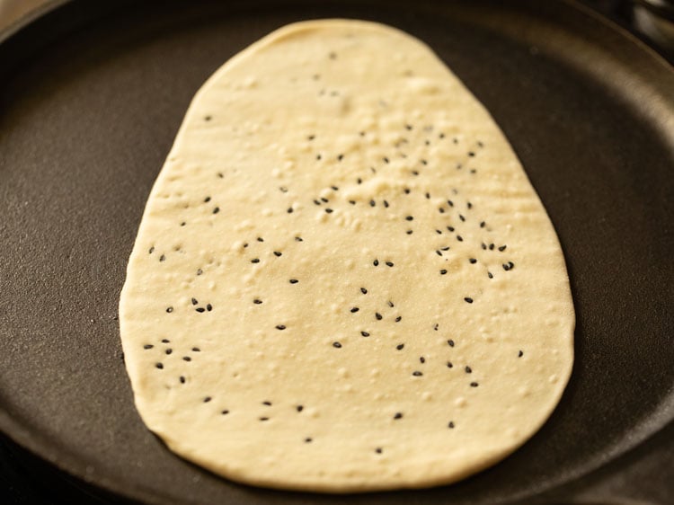 begin to cook naan on griddle