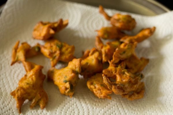 fried onion fritters on kitchen paper towels