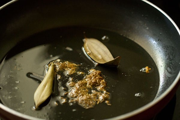 tej patta and cumin seeds in oil in a pan