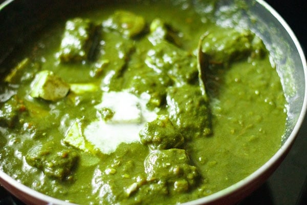 cream added to palak paneer in pan