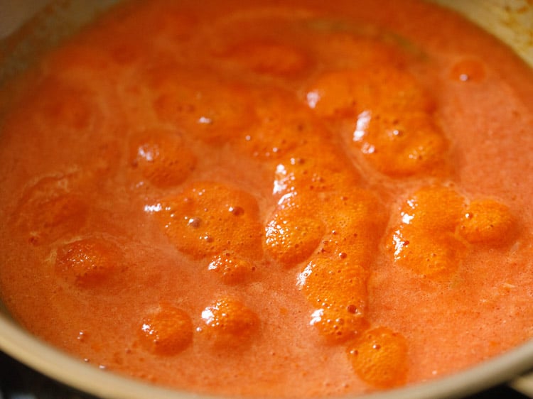 tomato purée simmering in the pan