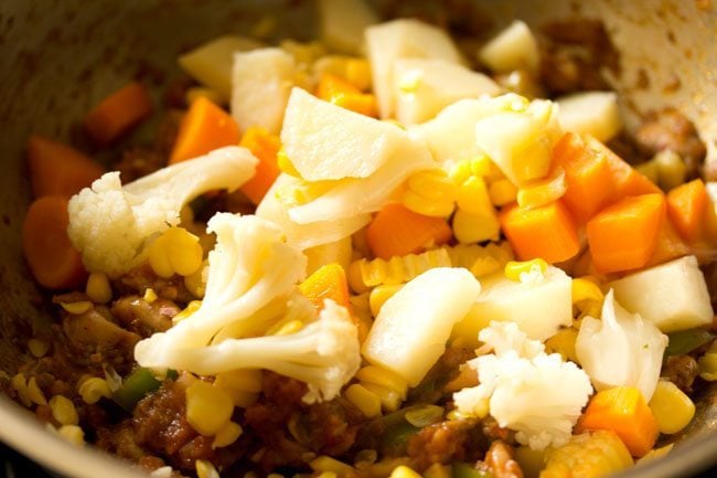 steamed mixed vegetables and corn kernels added to pan. 
