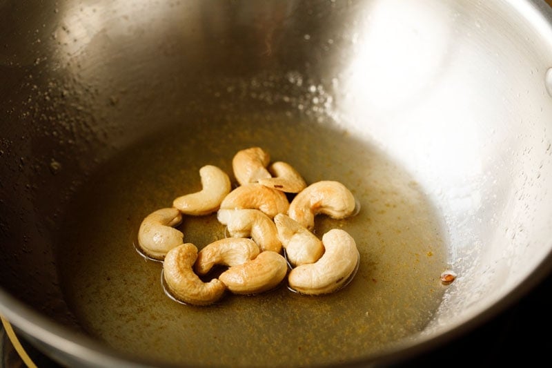 frying cashews in hot ghee for pinni recipe.