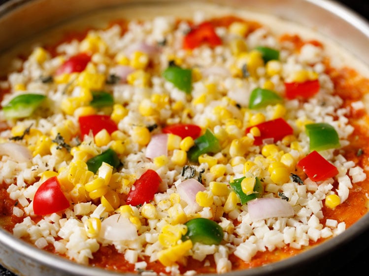 pizza topped with veggie cubes - green and red bell pepper, onion and steamed corn kernels