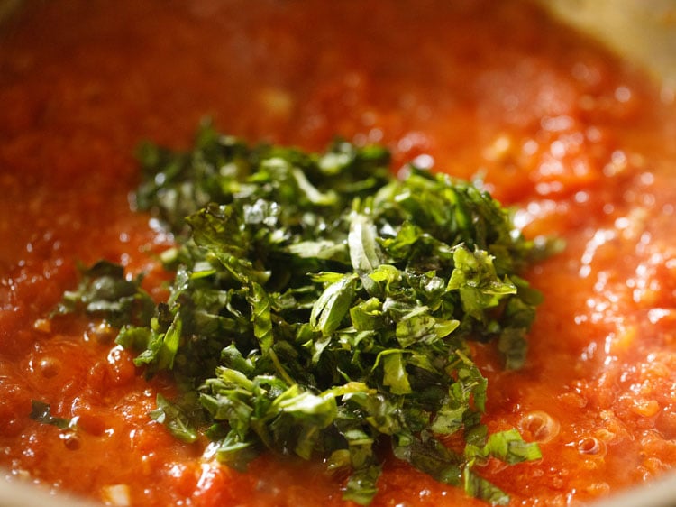 fresh basil added to pizza sauce